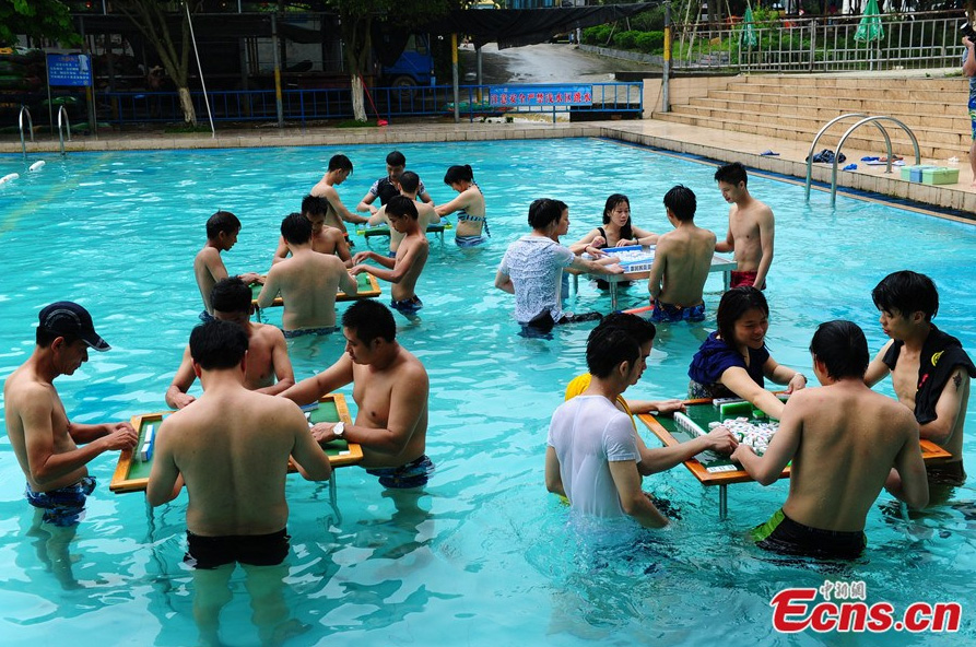 Players compete in a match during a mahjong contest held in a swimming pool at a scenic spot in Foshan, Guangdong province on June 24, 2014. Organized by Jiudaogu Rafting, an ecotourism spot in the Players compete in a match during a mahjong contest held in a swimming pool at a scenic spot in Foshan, Guangdong province on June 24, 2014. [Photo/Ecns.cn]