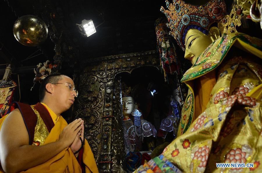 The 11th Panchen Lama Bainqen Erdini Qoigyijabu, who is also a member of the Standing Committee of the Chinese People's Political Consultative Conference (CPPCC) National Committee, worships a Buddha statue at the Jokhang Temple in Lhasa, capital of southwest China's Tibet Autonomous Region, July 2, 2014. The Panchen Lama made a research and inspection tour in Lhasa in recent days. [Photo/Xinhua]