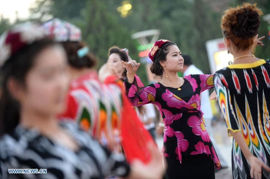 Citizens dance at the Maigaiti Dolan Culture Square in Maigaiti County, northwest China's Xingjiang Uygur Autonomous Region, June 29, 2014. Maigaiti County, known as the 'home of Dolan', has taken measures to protect and inherit the world intangible cultural heritage 'Dolan Muqam' since April 2012. [Photo/Xinhua]