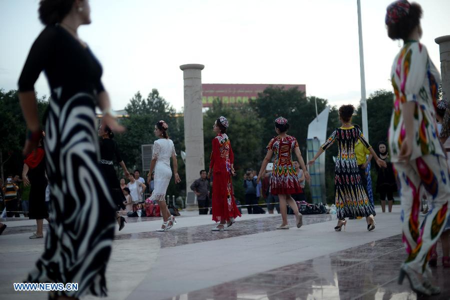 Citizens dance at the Maigaiti Dolan Culture Square in Maigaiti County, northwest China's Xingjiang Uygur Autonomous Region, June 29, 2014. Maigaiti County, known as the 'home of Dolan', has taken measures to protect and inherit the world intangible cultural heritage 'Dolan Muqam' since April 2012. [Photo/Xinhua]