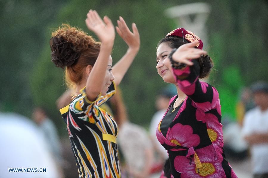 Citizens dance at the Maigaiti Dolan Culture Square in Maigaiti County, northwest China's Xingjiang Uygur Autonomous Region, June 29, 2014. Maigaiti County, known as the 'home of Dolan', has taken measures to protect and inherit the world intangible cultural heritage 'Dolan Muqam' since April 2012. [Photo/Xinhua]