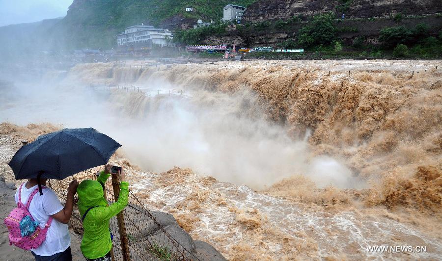 Tourists take photos of the Hukou Waterfall of the Yellow River, north China's Shanxi Province, July 9, 2014. [Photo/Xinhua]