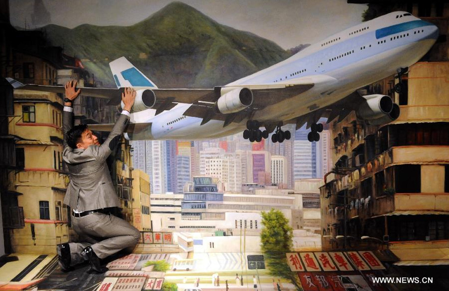 Visitors pose for a photo with a 3D image at the HK 3D Museum in Hong Kong, south China, June 26, 2014. The 3D art museum, the first of this kind in Hong Kong, was unveiled here on Thursday. [Photo/Xinhua]