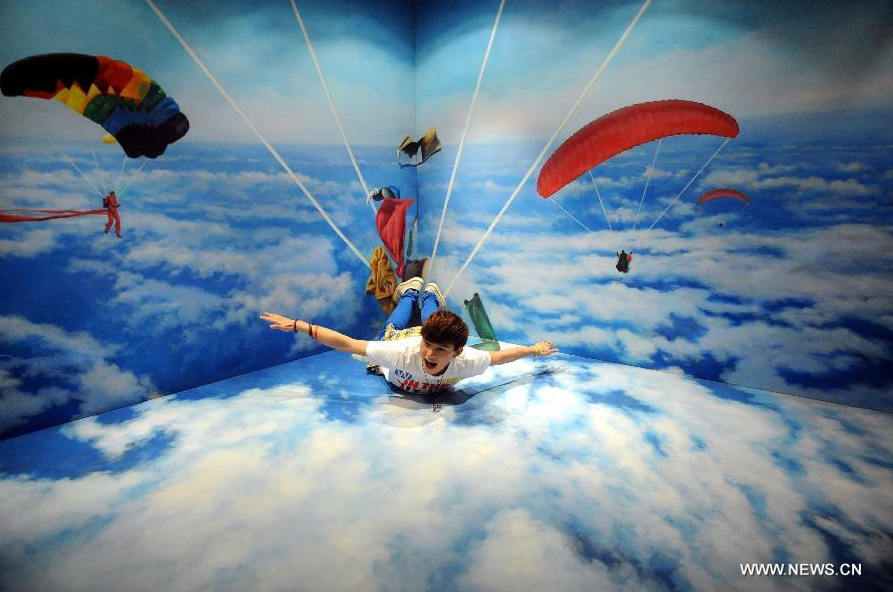 A visitor poses for a photo with a 3D image at the HK 3D Museum in Hong Kong, south China, June 26, 2014. The 3D art museum, the first of this kind in Hong Kong, was unveiled here on Thursday. [Photo/Xinhua]