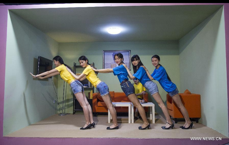 Visitors pose for photo during a 3D painting exhibition in southwest China's Chongqing, June 26, 2014. Over 200 pieces of 3D painting were on display. [Photo/Xinhua]