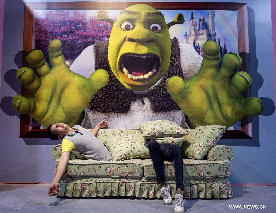 Visitors pose for photo during a 3D painting exhibition in southwest China's Chongqing, June 26, 2014. Over 200 pieces of 3D painting were on display. [Photo/Xinhua]