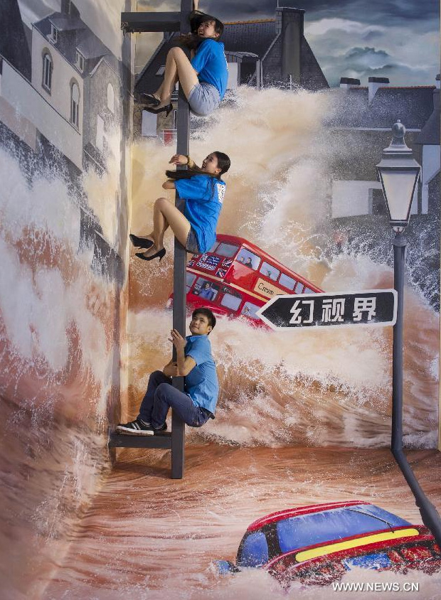 Visitors pose for photo during a 3D painting exhibition in southwest China's Chongqing, June 26, 2014. Over 200 pieces of 3D painting were on display. [Photo/Xinhua]