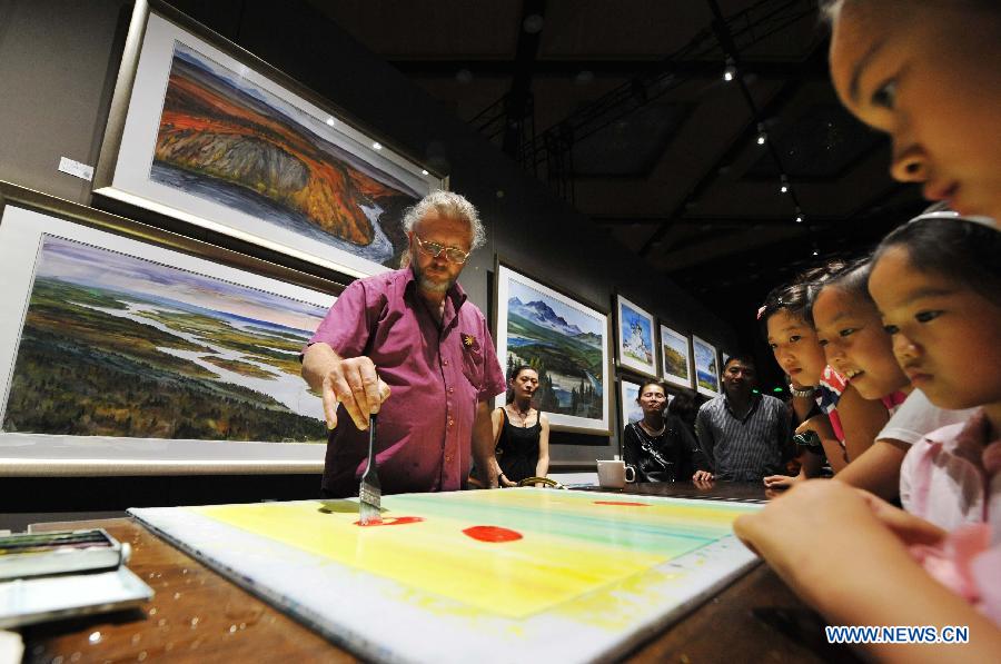 Children gather to watch a Russian artist painting at the China-Russia Expo (CR Expo) in Harbin, capital of northeast China's Heilongjiang Province, July 1, 2014. The expo, which kicked off on June 30, will last until July 4. [Photo/Xinhua]