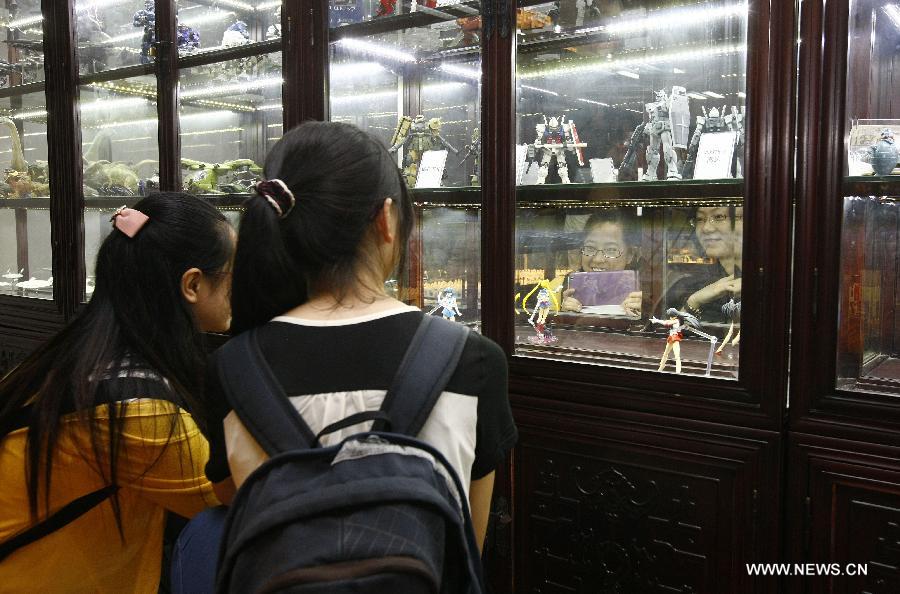 Visitors look at cartoon figures of Sailor Moon at an old toy exhibition in east China's Shanghai, July 2, 2014. The toys presented on the exhibition, from the collections of 18 collectors, remind visitors born in the 1970s and the 1980s of their childhood. [Photo/Xinhua]