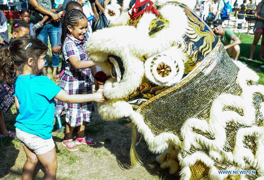 Kids watch lion dance during the 48th Smithsonian Folklife Festival in Washington D.C., capital of the United States, July 6, 2014. The 48th annual Smithsonian Folklife Festival closed in Washington on Sunday. [Photo/Xinhua]