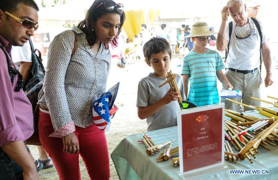 People view Chinese musical instruments during the 48th Smithsonian Folklife Festival in Washington D.C., capital of the United States, July 6, 2014. The 48th annual Smithsonian Folklife Festival closed in Washington on Sunday. [Photo/Xinhua]