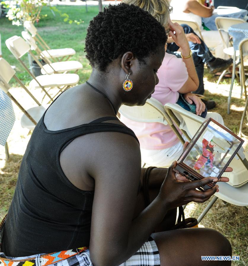 A visitor plays with a clay figurine during the 48th Smithsonian Folklife Festival in Washington D.C., capital of the United States, July 6, 2014. The 48th annual Smithsonian Folklife Festival closed in Washington on Sunday. [Photo/Xinhua]