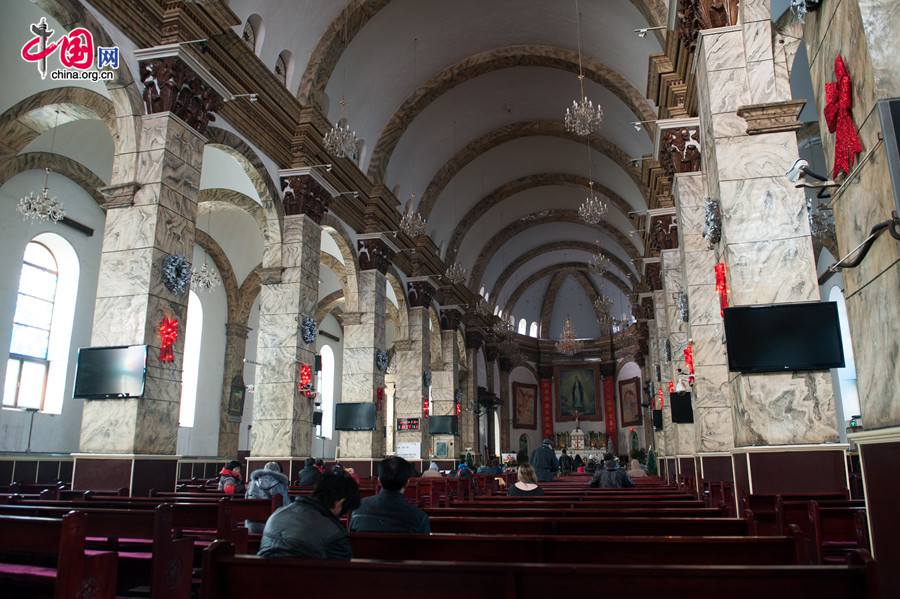 Believers pray before the statue of Jesus Christ in the Cathedral of the Immaculate Conception (colloquially known as the Xuanwumen Church, the South Church, or Nantang) in Beijing on the afternoon of Dec. 25, 2013, the Christmas Day. [Photo by Chen Boyuan / China.org.cn]